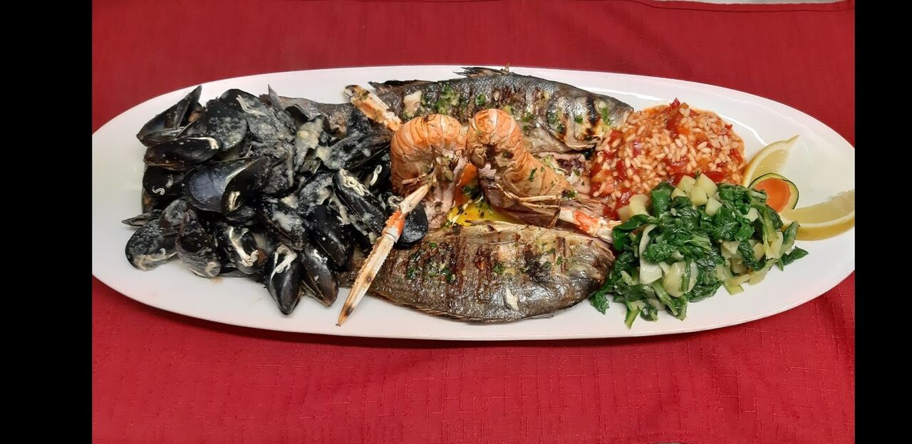 Fish platter grilled on flaming lava stone, which content fresh sea bass, dorada (gilt pol), scampi, squids, mussels
Fischplatte
