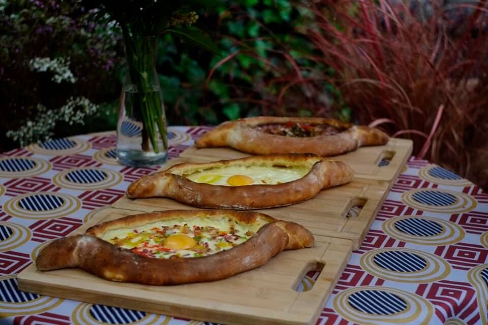 KHACHAPURI ATSCHARULI - gebackene Teigtasche in Schiffchenform, einem Ei und Butter , mit verschiedener Füllung