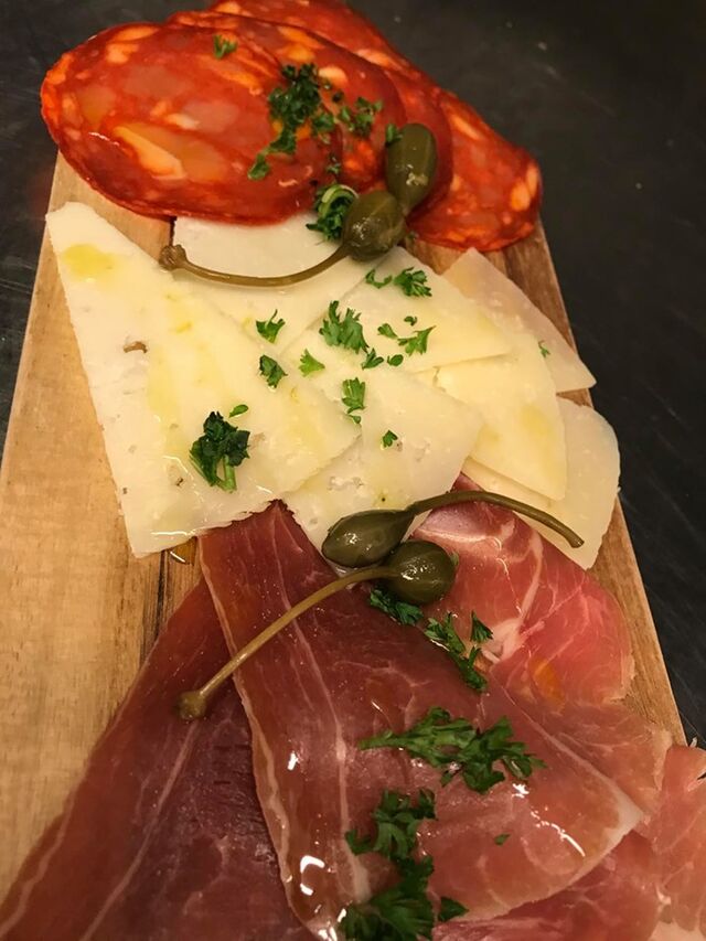 Een plankje met chorizo, manchego en serrano ham.
