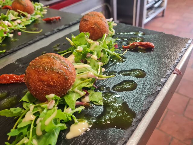  Ardoise d'Arancini ,sur un lit de roquette ,arancini farcie a la mozzarella et huile de basilique. pesto maison