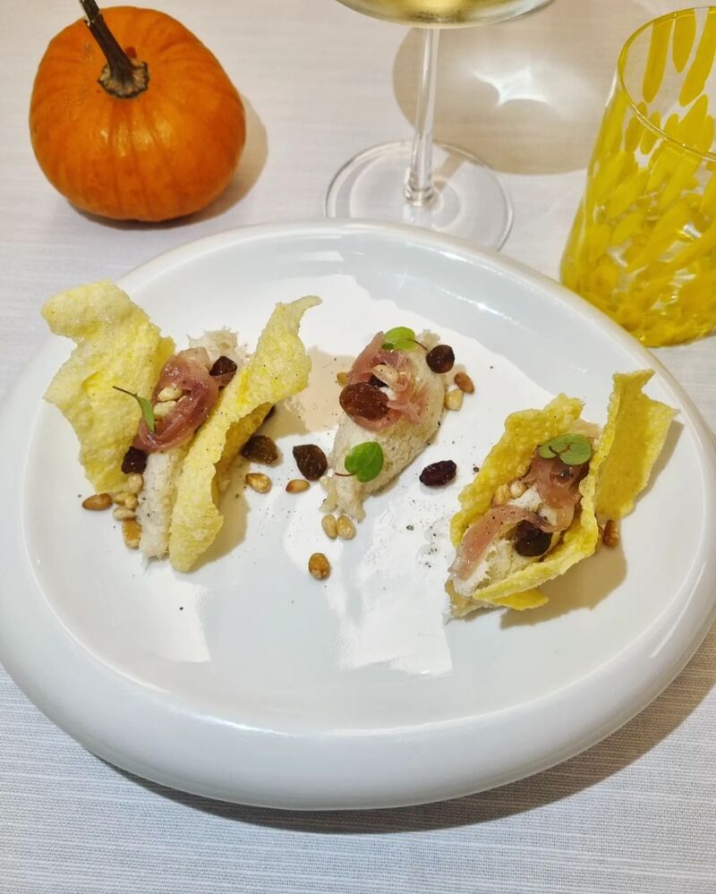 Sandwich di baccalà, cipolla caramellata, pinoli, uvetta e chips di polenta