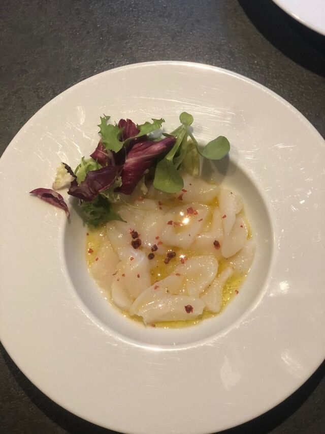 Carpaccio de Saint-Jacques, perles de baies rouges et herbes fraîches