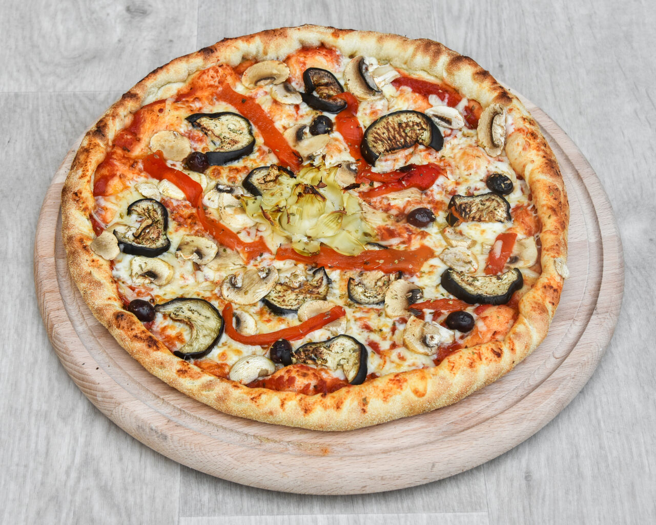 Tomate, fromage, champignons, artichauts, poivrons, aubergines et olives.33 cm.
