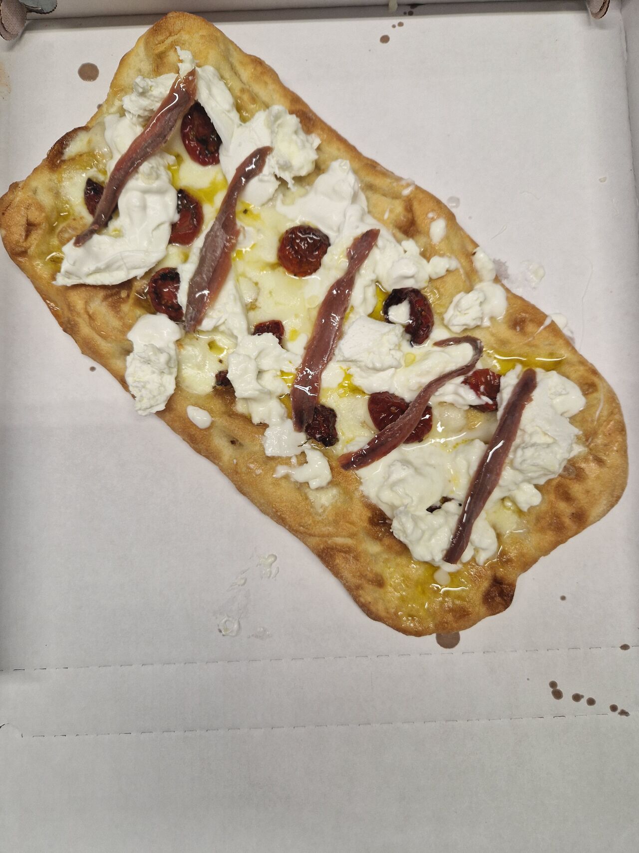 PINSA ROMANA CON ACCIUGHINE DEL CANTABRICO STRACCIATELLA E POMODORINI CONFIT