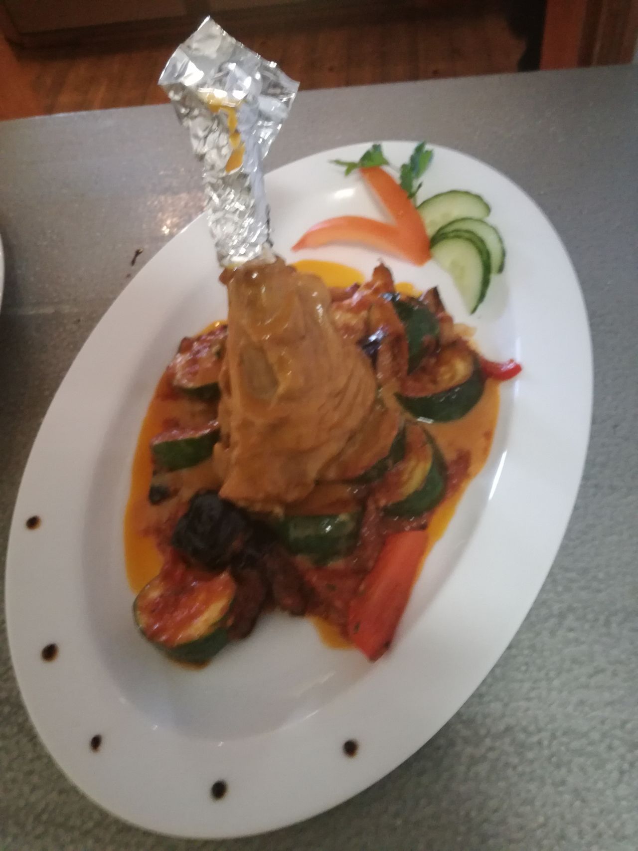 Lammhaxe in Rosmarinrahm auf mediterranem Gemüse