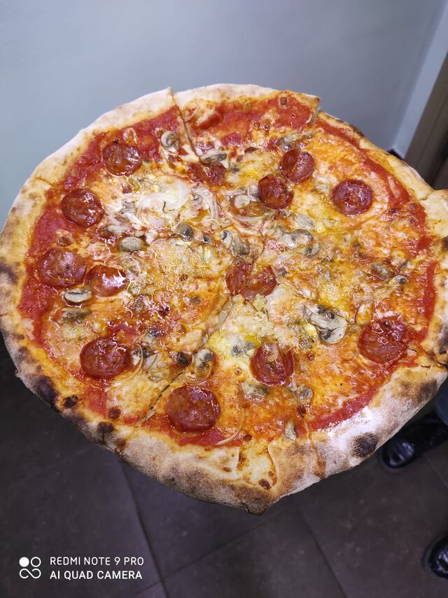 Pizza con salame piccante, funghi e cipolla bianca