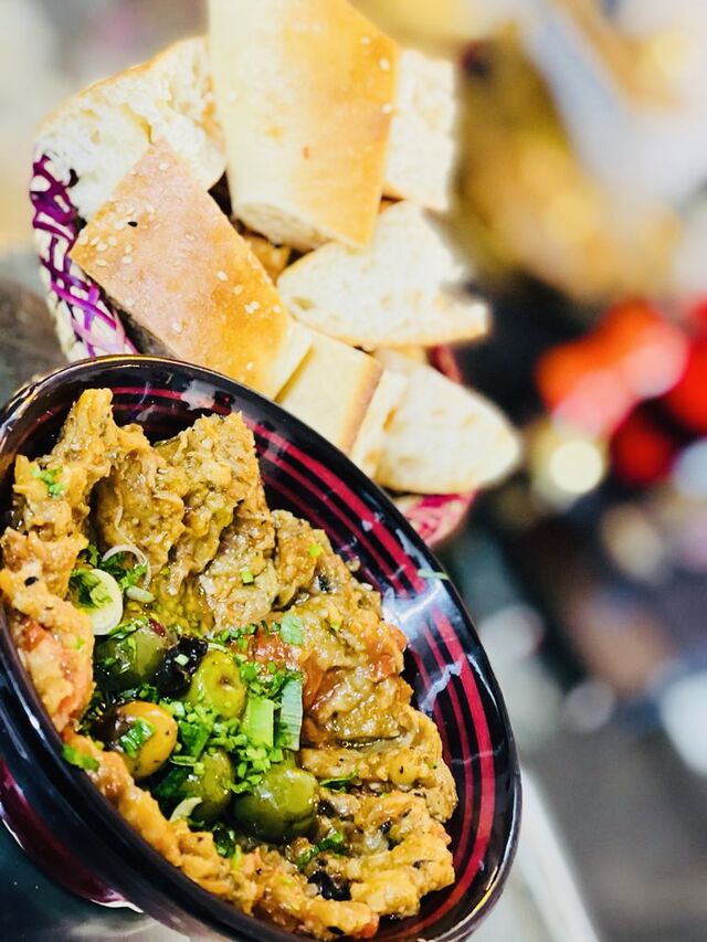 ZALOUK
Gegrillte feingehackte Auberginen mit eingelegter Zitrone, Knoblauch, Oliven, frischen Kräutern und arabischen Brot