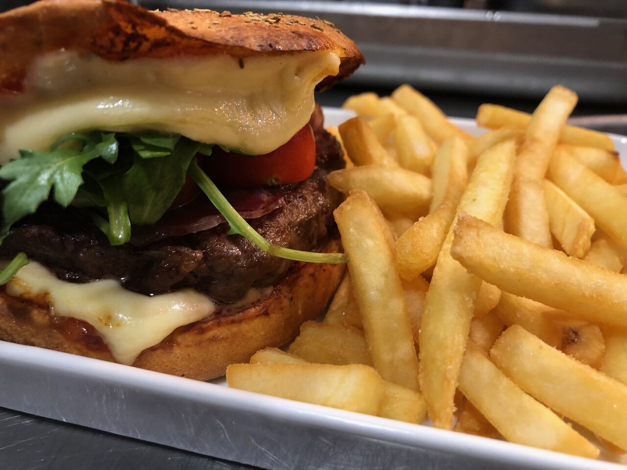 BURGER BRABBHAM 1960 : sauce tartare, steak haché de bœuf Black Angus (150gr), reblochon AOP, coppa, roquette, tomates cerises