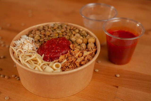 Plat vegetarien 100% (kouchary) mélange de pates avec du riz et du mais et du lentille avec sauce tomate et des ognions frits.