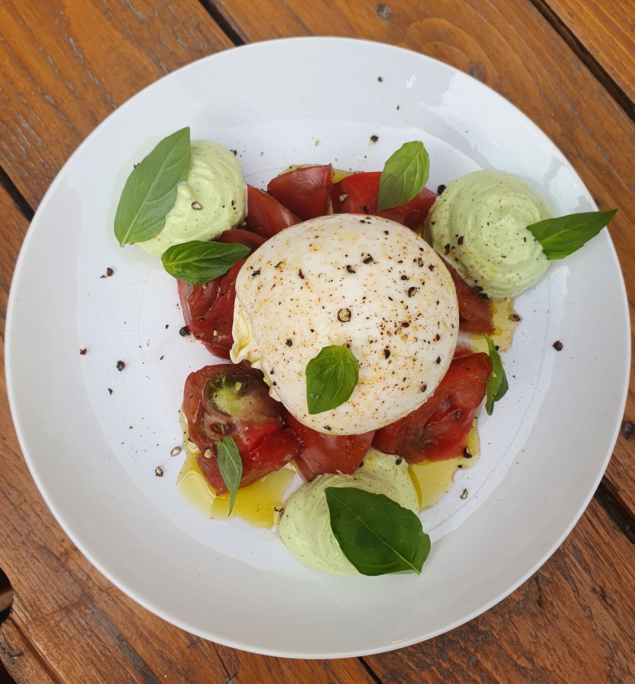 Burrata crémeuse sur son lit de tomates bordée de son espuma basilic