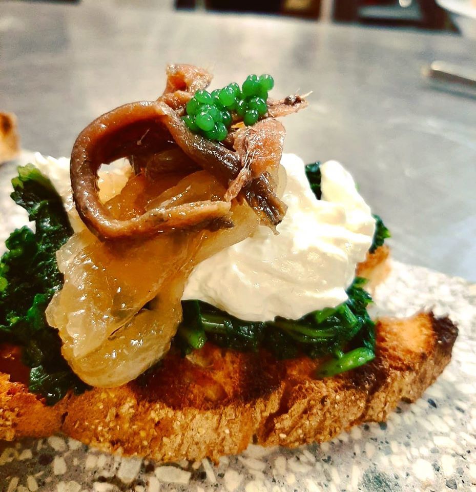 Crostone Robi: cavolo, burrata, cipolle caramellate, acciuga del Cantabrico, perlage di pesto