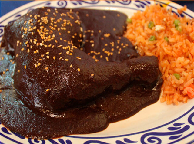 Pollo Mole Poblano: Piment sec, pruneaux, cacao, cacahuètes, amandes, raisins secs, graines de sésame, cannelle, épices.