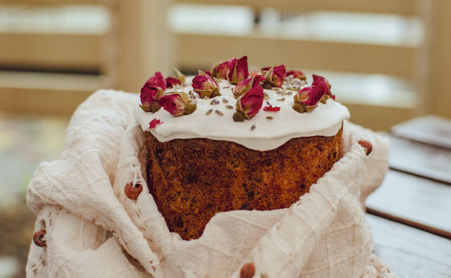 Паска бездріжджова сирна з родзинками, декорована білою помадкою, сушеною чайною трояндою і лавандою.