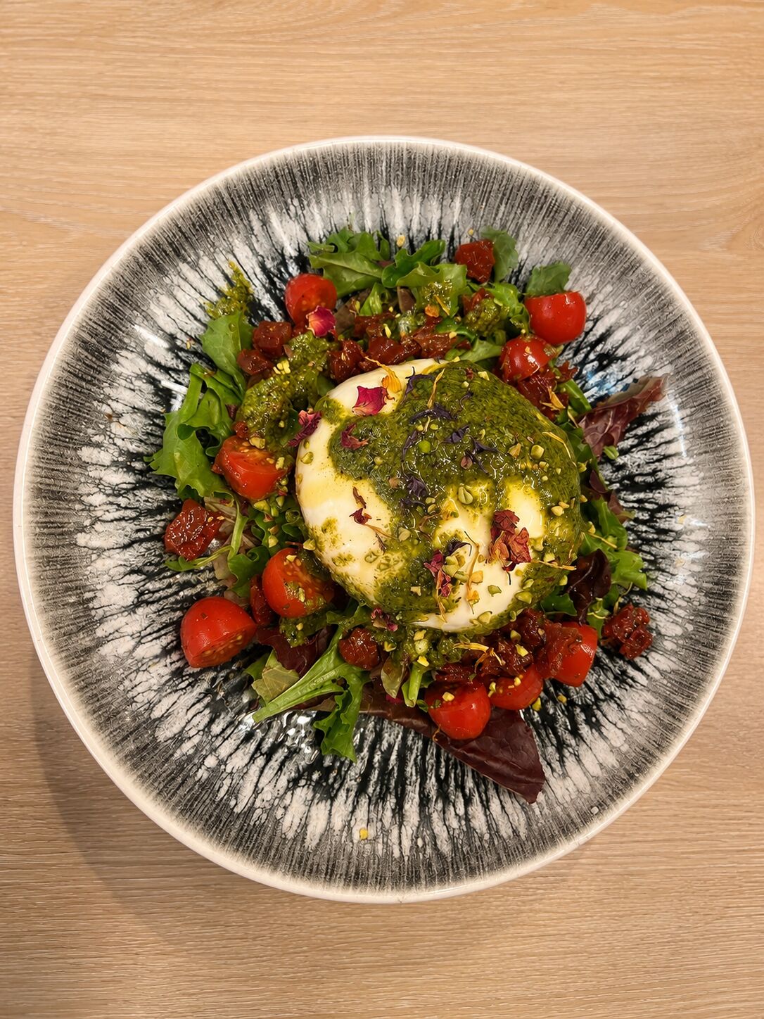 burrata cremosa dúo de tomates brotes de temporada y Pesto de pistacho