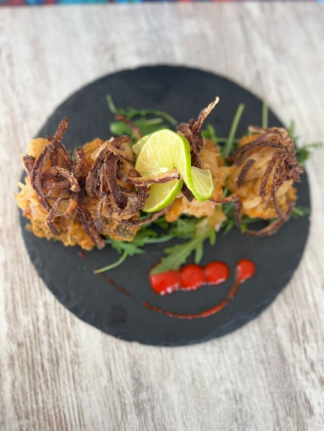 Tacos de bacalao frito con rucola y cebolla confitada
