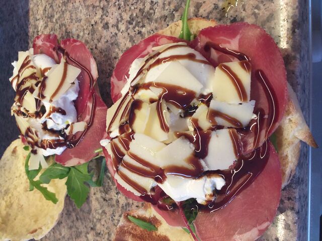 Notre Puccia 'Gourmande': roquette, coppa, burrata de 125gr, copeaux de grana, huile d'olive extra vierge, crème balsamique ??