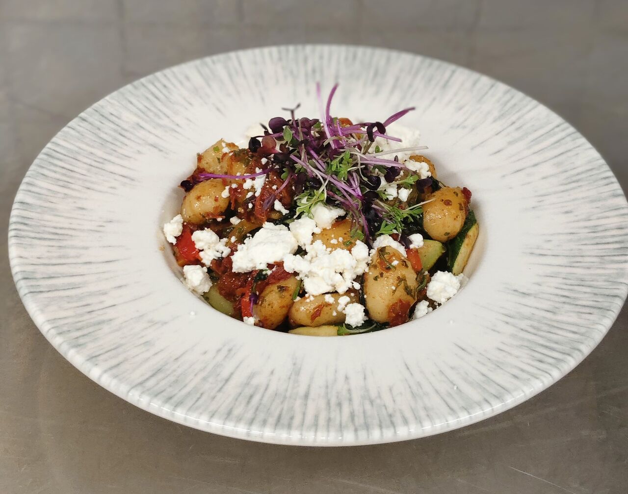 Erdäpfelnockerl mit Zucchini, eingelegten Paprika und Tomaten, Schafkäse und Babyspinat