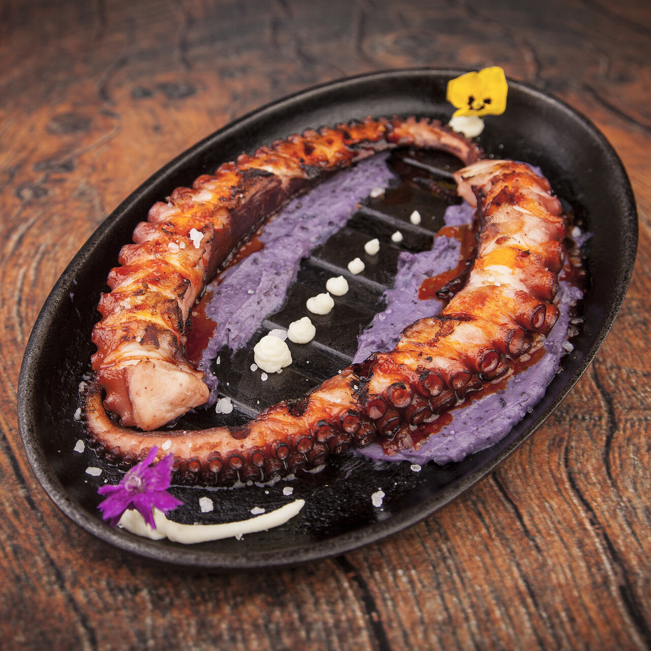 Pulpo a las brasas con crema de patata azul.