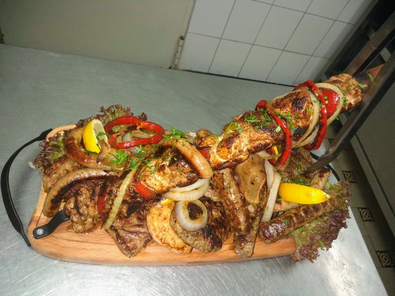 Gemischter Grillteller auf einem Holzbrett: 1 Großer Spieß, 2 Nacken Steak und 2Hähnchen Brust, 2 ,kebapceta, Rumsteak.