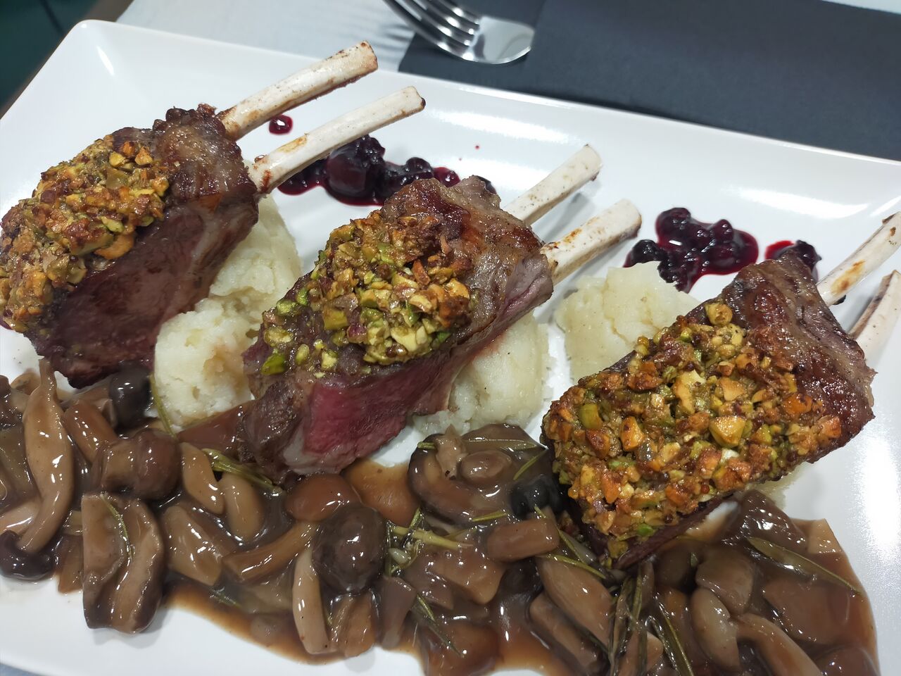 Rack de cordero con costra de pistacho y salsa de setas