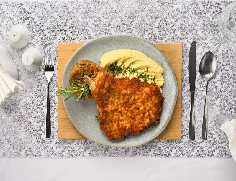 Tradycyjny kotlet schabowy z kością puree, kapusta zasmażana Alergeny (1,3,7) 39 zł