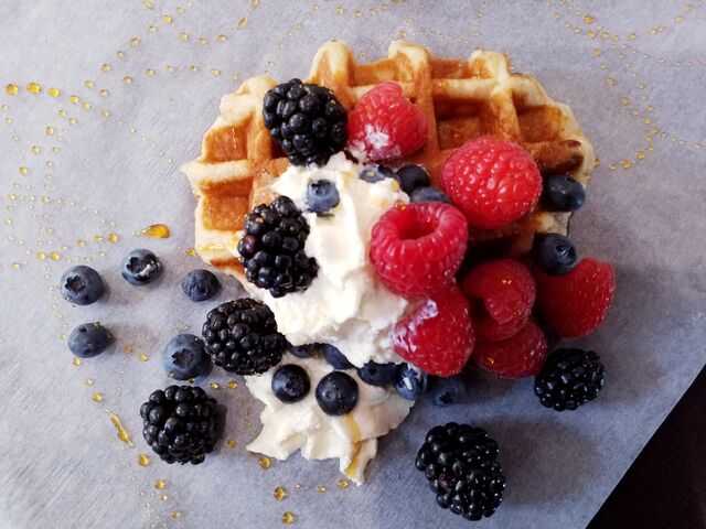 Waffle con frutti di bosco, panna montata e sciroppo d'acero