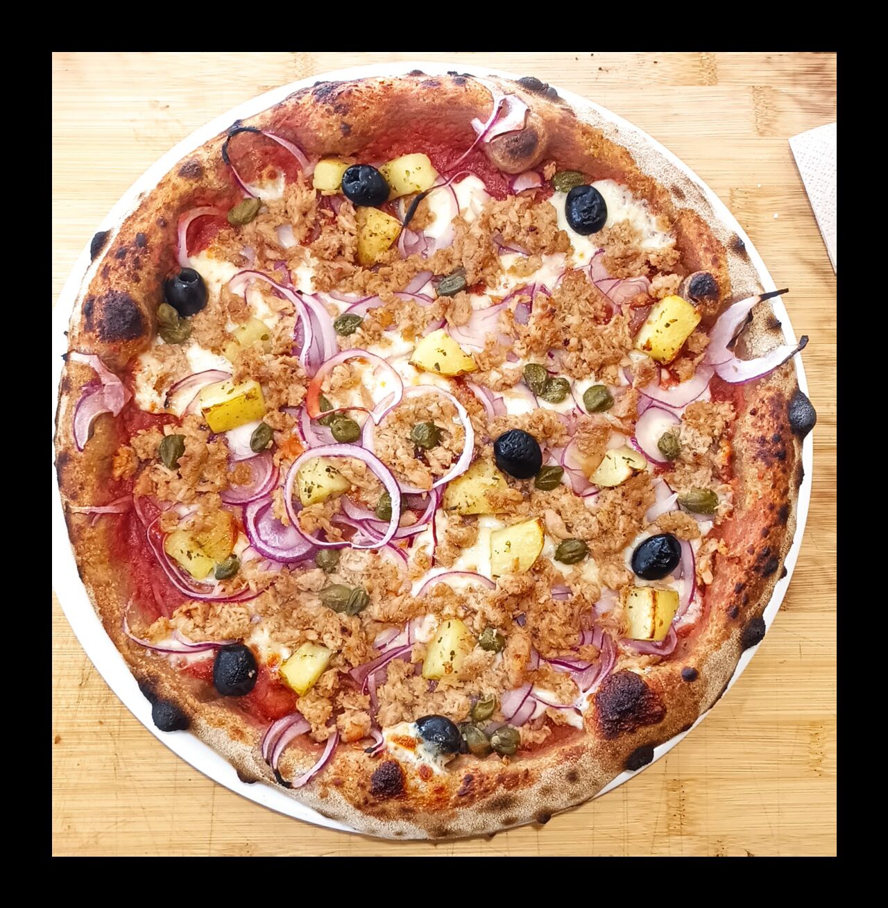 Pizza Tonno - base tomate, mozza FDL, oignons rouges, pommes de terre rôties, câpres, thon, olives noires