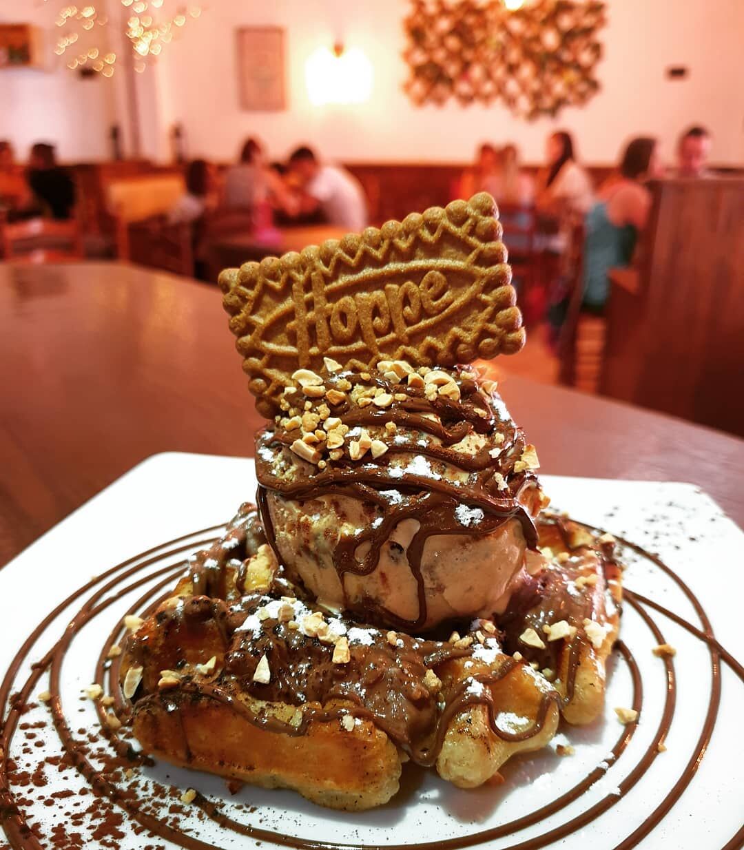 Gofre calentito con crema de Ferrero Rocher, chocolate, crocante de almendra, galleta speculoos y culminado con helado de kinder