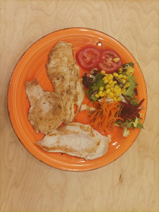 Plato de filetes de pollo con ensalada.