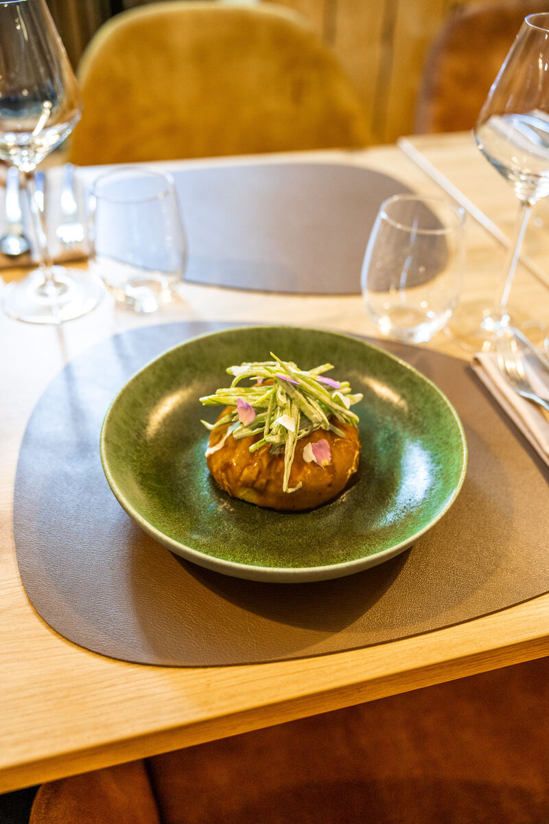 Le Pain Bao garni d'un effiloché de joue de porc, Épinards, Lin, Jus de viande, Pois gourmand