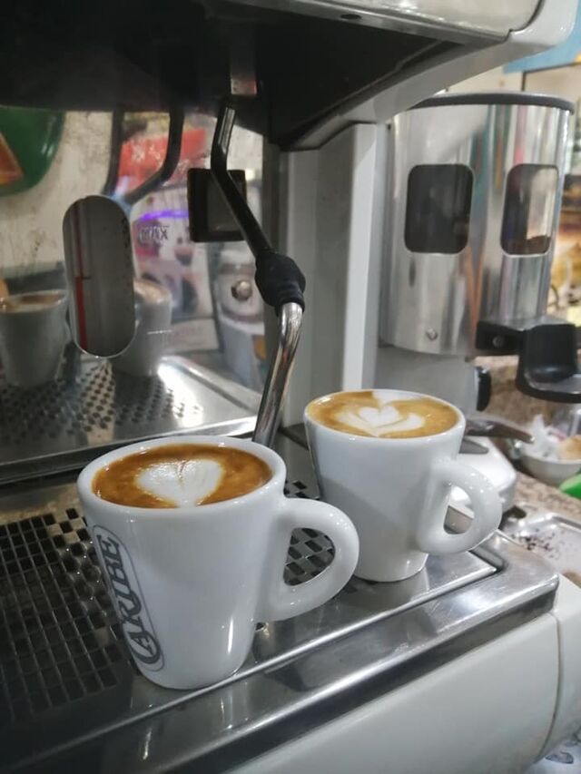 panino condito con pomodoro, mozzarella e insalata,due caffè macchiati
