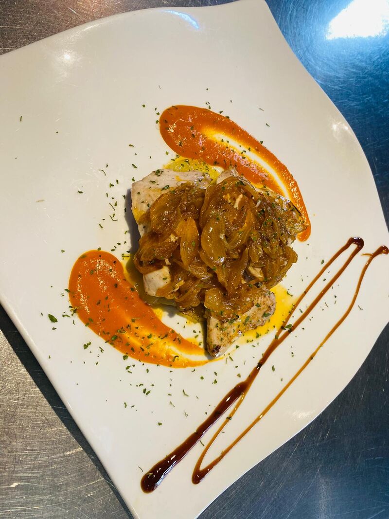 Bacalao encebollado sobre cama de patatas panaderas 