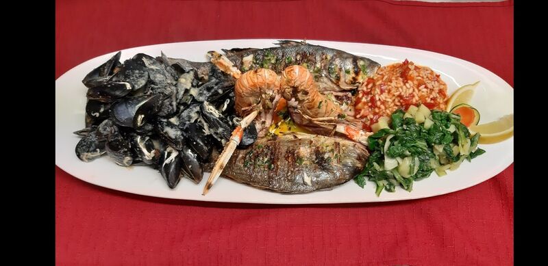 Fish platter grilled on flaming lava stone, which content fresh sea bass, dorada (gilt pol), scampi, squids, mussels
Fischplatte