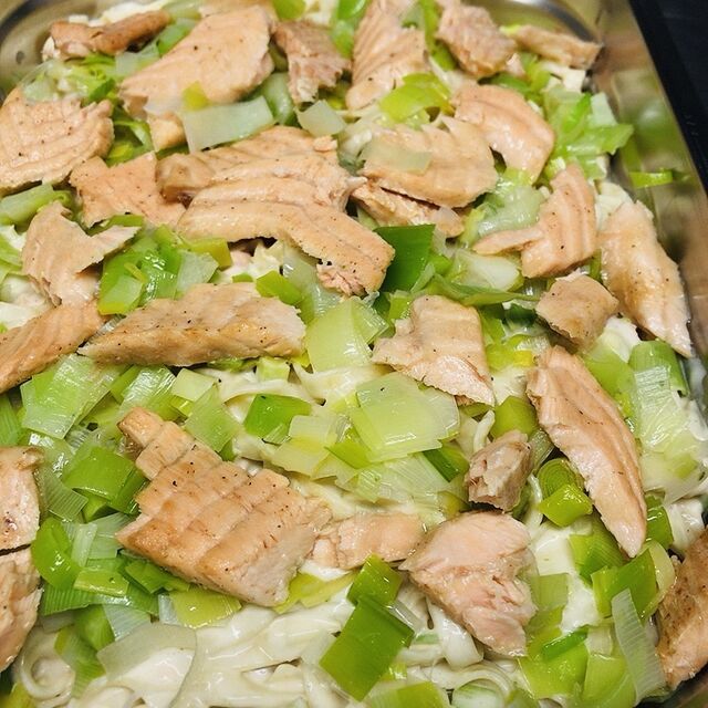 Pasta met vers gepocheerde zalm, prei en een zachte witte wijnsaus.