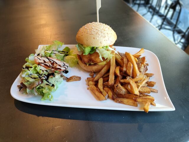 Burger Chicken ( pain maison, poulet pané, poivrons, oignons caramélisés, salade, parmesan, mayonnaise curry) 