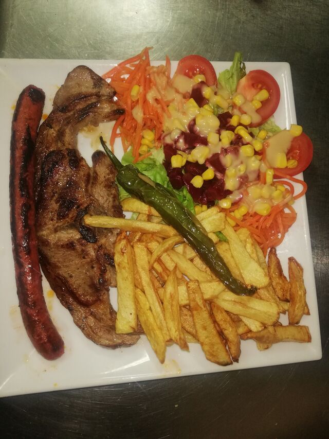 Assiette deux viandes avec pommes frites salade et piment