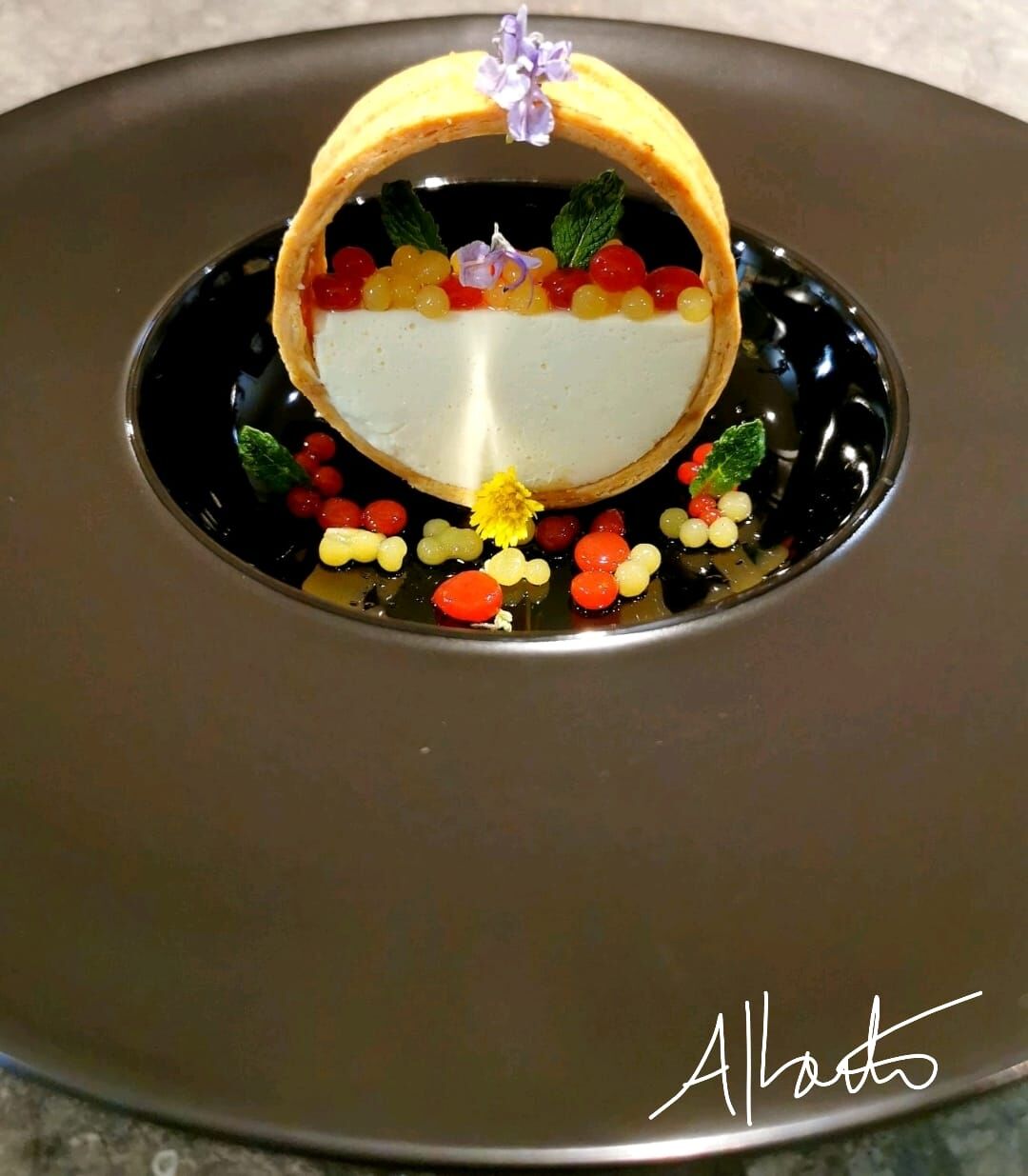 Perles de mangue gingembre et fraise romarin sur une panna-cotta au chocolat blanc entourée de son biscuit.