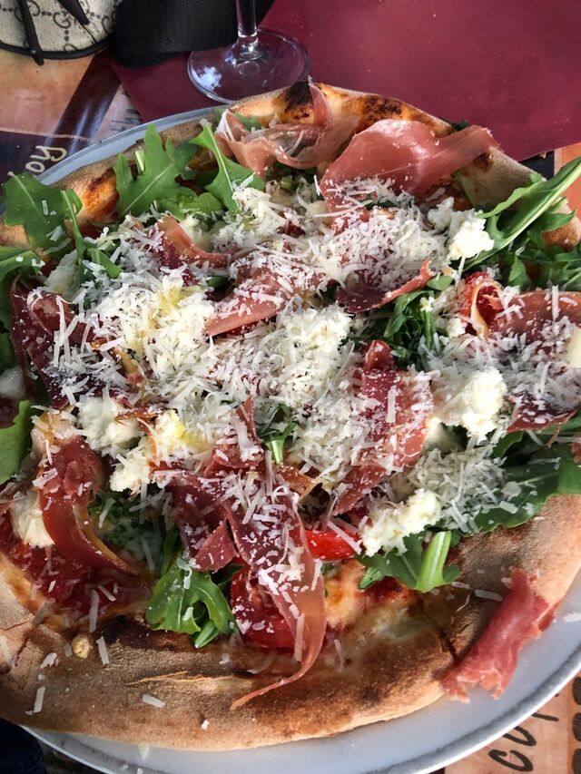 Pizza mit Parmaschinken, Büffelmozarella, Rucola & Parmesan 