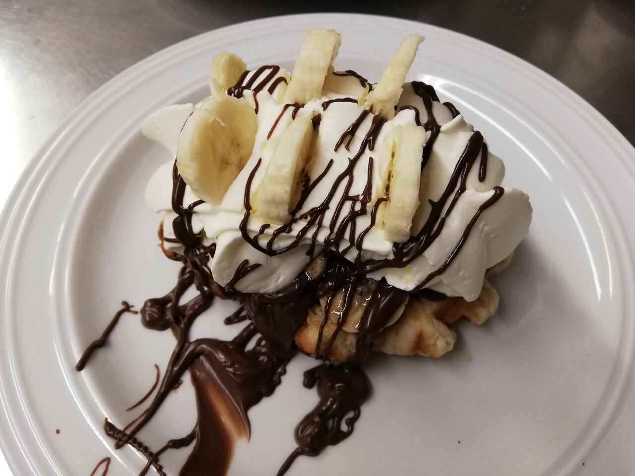 Gepimpte suikerwafel met slagroom en banaan, afgewerkt met choco.
Ook 