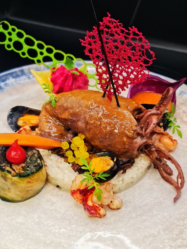 Encornet farci Risotto noir , moules bouchot et homard. Bisque au safran et choucroute de papaye. 