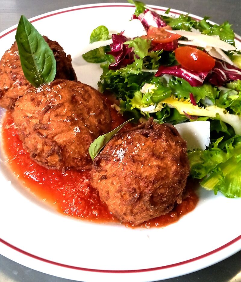 Arancini de spaghetti frit à la méthode du chef sur lit de sauce tomate