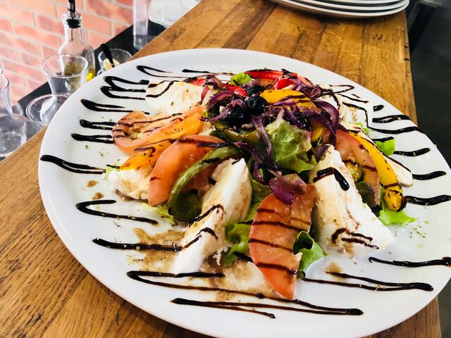 Venez déguster notre salade composée de tomate, mozzarella, olive, poivrons 