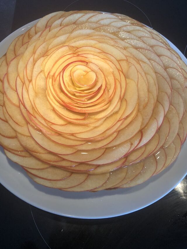 Tarte aux pommes avec un sablé une crème d'amandes, compote de pommes maison et des pommes ainsi qu'un nappage.