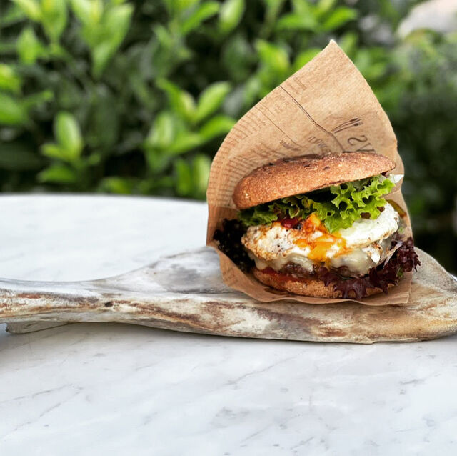 Deluxe Burger: Beef, Kas, Bacon, Ei, Jalapeno, Gewürzgurken, Tomaten, Zwiebeln und BBQ Sause 