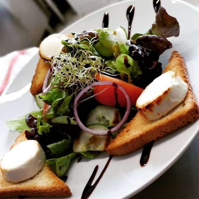 Toasts de chèvre chaud au miel gratinés et salade verte.