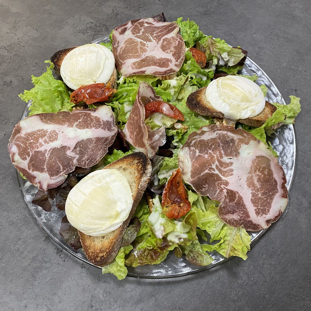 Salade Coppa - Cabécou
Sur lit de salade, de fines tranches de Coppa et toasts de Cabécou gratinés, tomates confites, noix