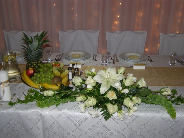 Przykładowa dekoracja z żywych kwiatów na stole dla Pary Młodej.