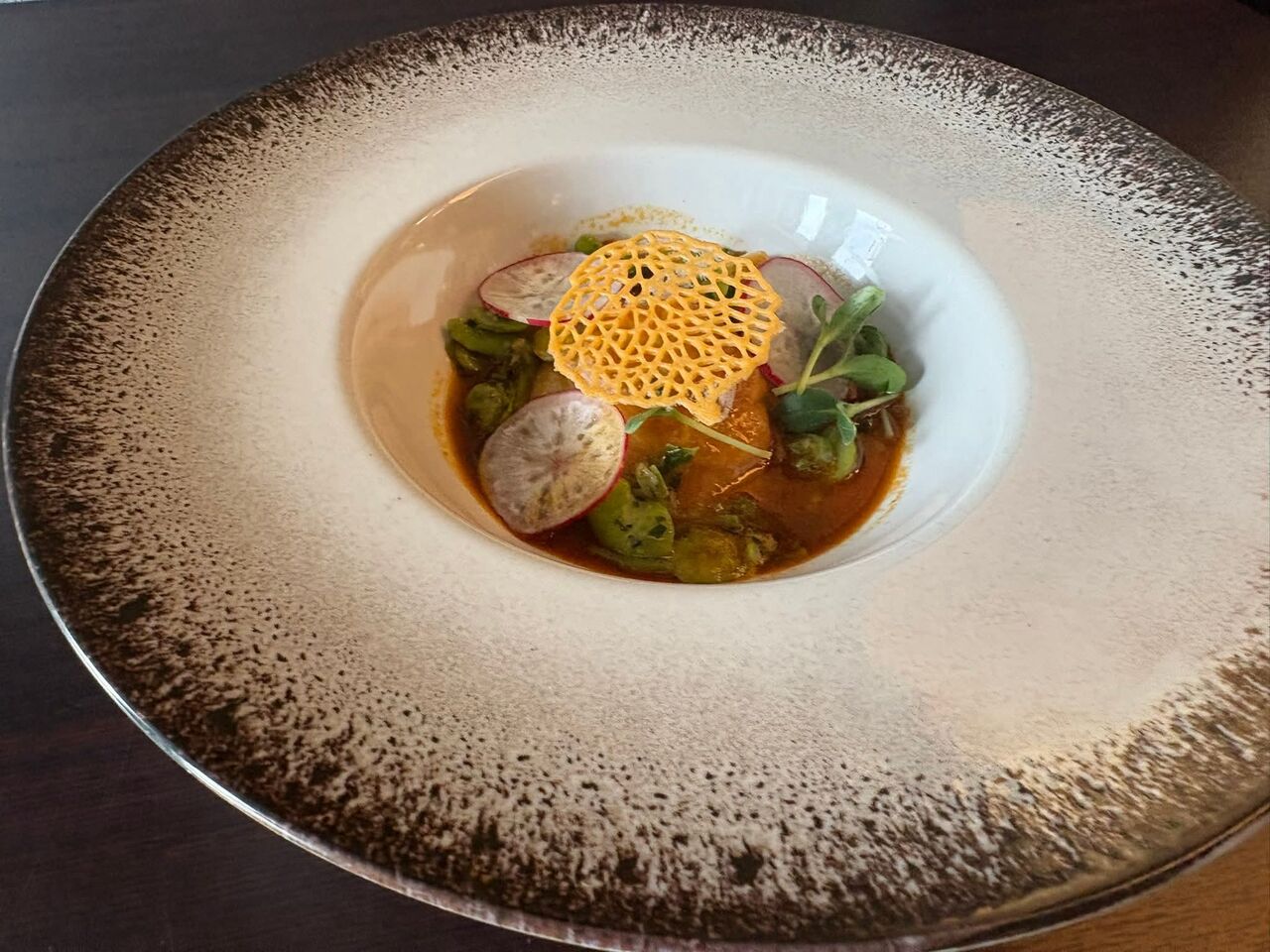 Raviole de homard à l’armoricaine, huile safran et combava, fondue de poireaux au safran, févettes et radis