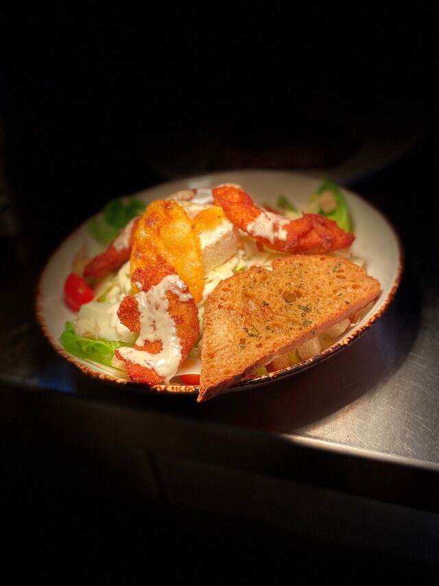 Salade Caesar :
Salade iceberg, cœur de sucrine, aiguillettes de poulet panées maison, œuf mollet, tomates cerises, parmesan