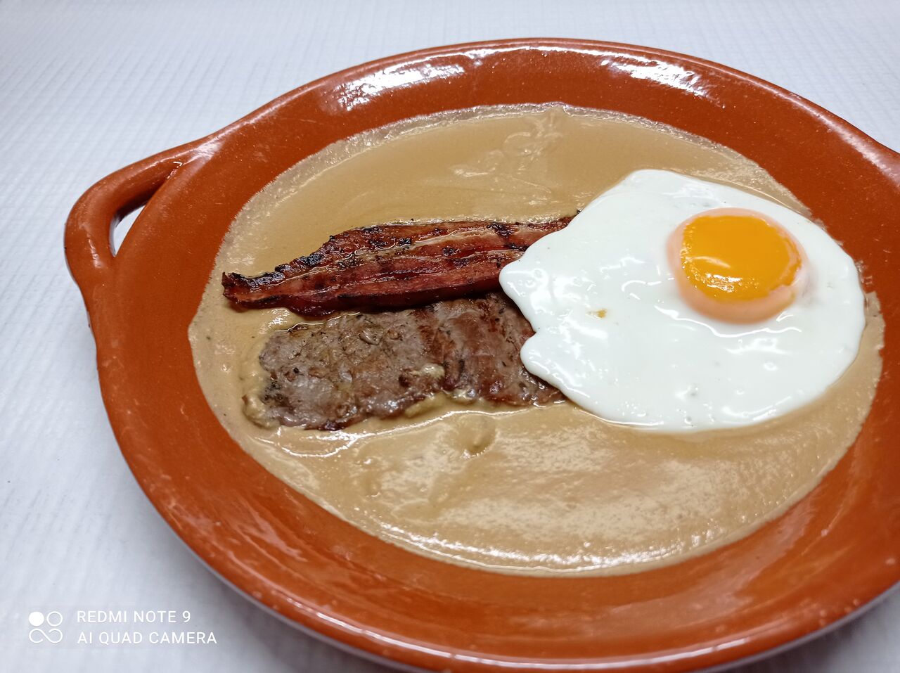 Bife na frigideira, com bacon, ovo estrelado, batata frita e o nosso molho.